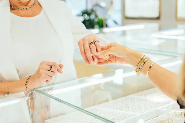 Feche Mãos Mulher Seniores Com Anéis Ouro Pulseiras Sobre Exposição — Fotografia de Stock