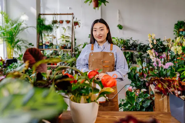 创办小企业的概念 花店内部年轻的韩国女店主头戴围裙站在柜台后的画像 — 图库照片