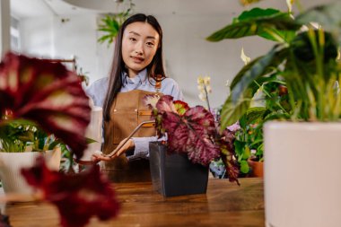 Neşeli Bayan Sahibi Çiçek İşindeki Bağlılığıyla Çiçek Açmaya Çalışıyor. Büyüleyici İş Kadını Butik Cenneti 'nde Bitkileri Yetiştiriyor