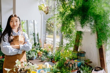 Küçük işletme, ev dekorasyonu konsepti. Profesyonel portresi. Kendine güvenen genç Asyalı kadın çiçekçi, küçük bir çiçekçinin sahibi. Boşluk metnini kopyala.
