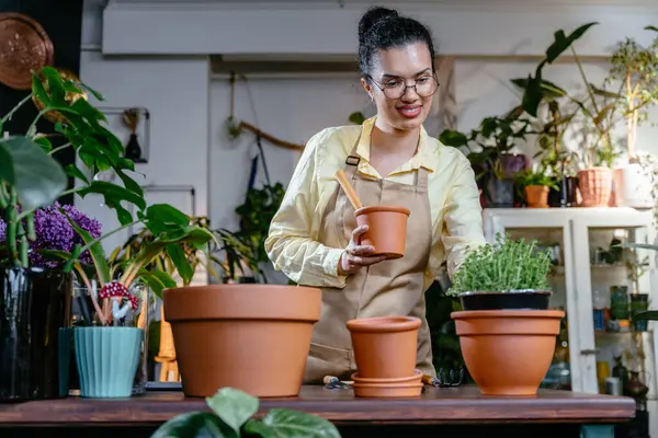 Smilling shop asistanı kapalı saksı fabrikasında çalışıyor, küçük işletme, girişimci ve meslek konsepti.