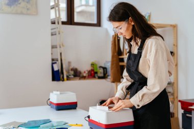 Atölyede cam öğütme. Boyalı cam üretimi. El işi. Yaratan genç bir kadın. Cam öğütücü. Hobiler, sanat ve el sanatları konsepti.