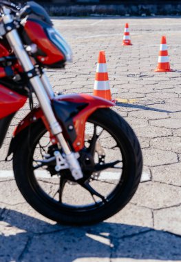 Motorsiklet kısmını kapat. Arka planda turuncu koniler var. Motosiklet sürüş okulu kavramı. Koniler arasında gezmek, motosiklet okulunda ders. Kimse.