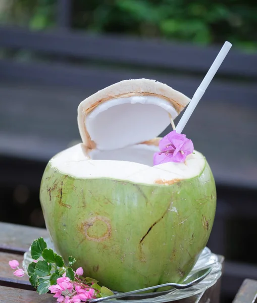 stock image green coconuts water with drinking straw on the table