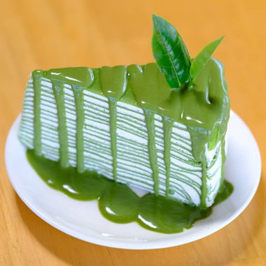 Ahşap masada yeşil çay krepi.