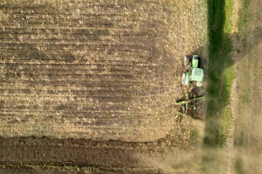 Açık kırsaldaki toprağın kış hazırlıklarını yapan bir traktörün havadan çekilmiş belgeseli. 