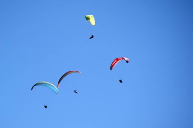 Bir grup paraşütçünün uçtuğu anın fotoğraflı belgeleri mavi gökyüzüne savruldu.