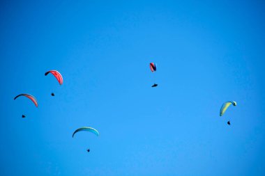 Bir grup paraşütçünün uçtuğu anın fotoğraflı belgeleri mavi gökyüzüne savruldu.