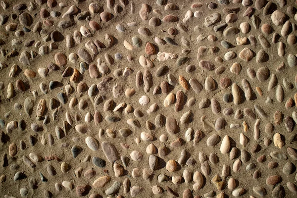 Photographic documentation of an outdoor floor made with river stones and sand
