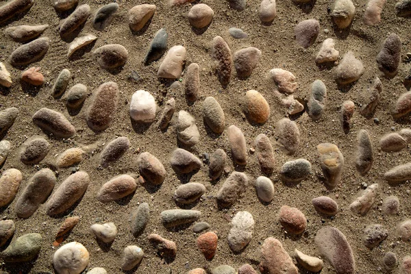 Photographic documentation of an outdoor floor made with river stones and sand