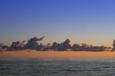 Bulutların gün batımında denizin üzerinde çekilmiş fotoğrafları. 