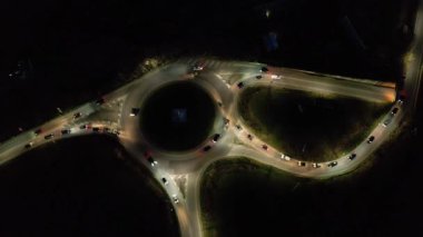Şehir kavşağındaki trafiğin gece görüntüsü. 