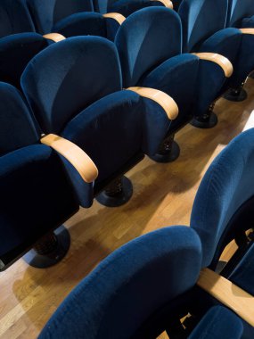 Boş bir tiyatroda dizilmiş mavi kadife koltukların fotoğraf dökümanları, hafif ahşap kolluklar ve parke döşemeler.. 