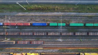 Paralel olarak dizilmiş bazı renkliler de dahil olmak üzere birkaç vagonlu bir nakliye deposunun hava görüntüsü.. 