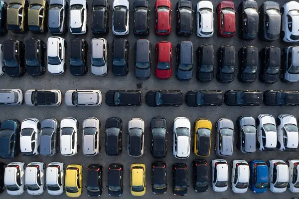 SatıImayı bekleyen büyük bir araba deposunun havadan çekilmiş fotoğrafları. Düzenli sırada, güneşli bir günü gösteren gölgelerle birlikte.. 