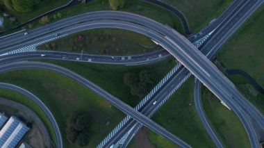 Çevresi yeşilliklerle çevrili karmaşık bir otoyol kavşağının detaylı hava görüntüleri.. 