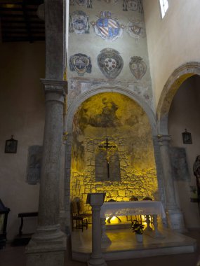 Aydınlatılmış sunak, haç, ortaçağ freskleri ve duvarda asil arma arması olan Romanesk bir kilisenin fotoğraf dokümanları.. 