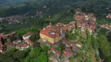 Ortaçağ köyü Montecatini Alto 'nun taştan evleri ve çevresindeki bitki örtüsüyle panoramik manzaranın hava belgeseli.. 