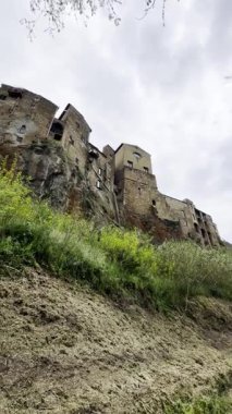 Tuscany 'deki ortaçağ köyü Pitigliano' daki antik Tuff evlerinin manzarasının video kayıtları, bir uçurumun tepesine inşa edilmiş, bulutlu bir günde çekilmiş. 