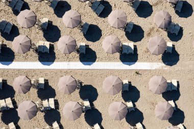 Sezonun başında Versilia plajındaki imalı şemsiyelerin havadan görünüşünün fotoğraflı belgesi.,