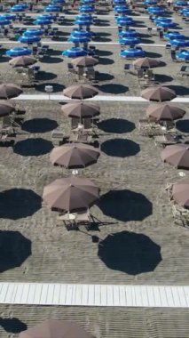 Sezonun başında Versilia plajındaki müstehcen şemsiyelerin hava görüntülerinin video kayıtları. Geometriler, yumuşak renkler ve rahatlatıcı bir atmosfer 