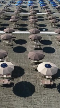 Sezonun başında Versilia plajındaki müstehcen şemsiyelerin hava görüntülerinin video kayıtları. Geometriler, yumuşak renkler ve rahatlatıcı bir atmosfer 