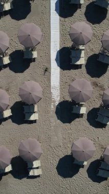 Sezonun başında Versilia plajındaki müstehcen şemsiyelerin hava görüntülerinin video kayıtları. Geometriler, yumuşak renkler ve rahatlatıcı bir atmosfer 