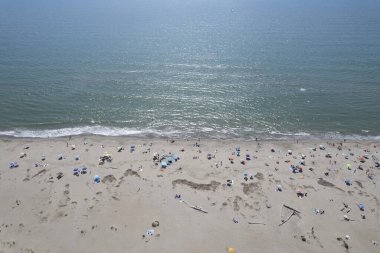 Yüzen ve renkli şemsiyeli doğal bir sahilin havadan görünüşü, yaz, özgürlük ve deniz kıyısında dinlenme.. 