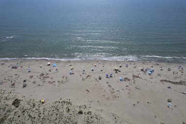 Yüzen ve renkli şemsiyeli doğal bir sahilin havadan görünüşü, yaz, özgürlük ve deniz kıyısında dinlenme.. 