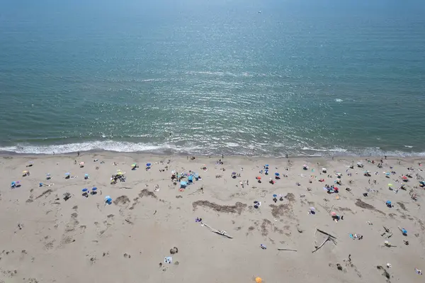 Yüzen ve renkli şemsiyeli doğal bir sahilin havadan görünüşü, yaz, özgürlük ve deniz kıyısında dinlenme.. 