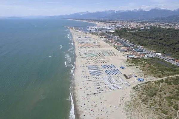 Renkli şemsiyeler ve canlı yaz atmosferiyle düzenlenmiş Viareggio plajının nefes kesici hava manzarası.. 