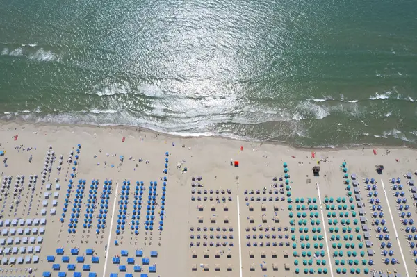 Renkli şemsiyeler ve canlı yaz atmosferiyle düzenlenmiş Viareggio plajının nefes kesici hava manzarası.. 