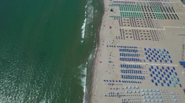 Viareggio sahilinin renkli şemsiyelerle donatılmış havadan çekilmiş video görüntüleri, canlı yaz atmosferi.. 