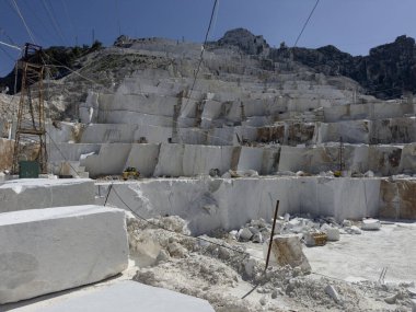 Beyaz mermerdeki derin kesikler, insanın gücünü ve dağın kırılganlığını vurgular.. 