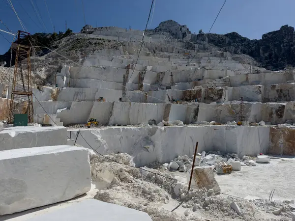 Beyaz mermerdeki derin kesikler, insanın gücünü ve dağın kırılganlığını vurgular.. 