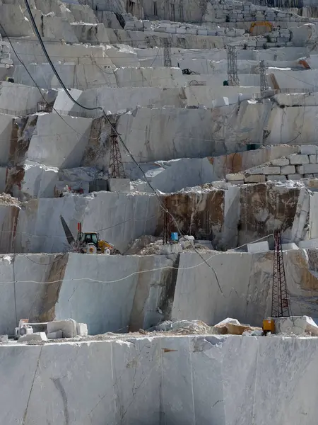 Beyaz mermerdeki derin kesikler, insanın gücünü ve dağın kırılganlığını vurgular.. 