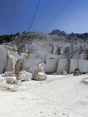 Beyaz mermerdeki derin kesikler, insanın gücünü ve dağın kırılganlığını vurgular.. 