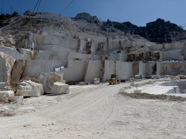 Beyaz mermerdeki derin kesikler, insanın gücünü ve dağın kırılganlığını vurgular.. 