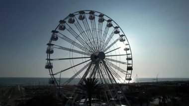 Yazın ve turizmin sembolü Lido di Camaiore, Versilia Tuscany 'de gün batımında gökyüzüne karşı çağrıştıran dönme dolap.. 