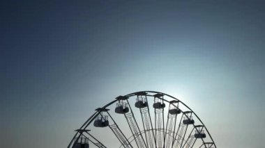 Yazın ve turizmin sembolü Lido di Camaiore, Versilia Tuscany 'de gün batımında gökyüzüne karşı çağrıştıran dönme dolap.. 