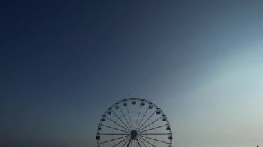 Yazın ve turizmin sembolü Lido di Camaiore, Versilia Tuscany 'de gün batımında gökyüzüne karşı çağrıştıran dönme dolap.. 