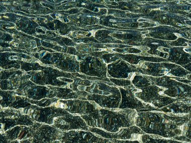 Eşsiz ışık oyunları yaratan, deniz tabanındaki çakıl taşlarını ve renkli yansımaları ortaya çıkaran dalgalarla büyüleyici su dokusu.. 