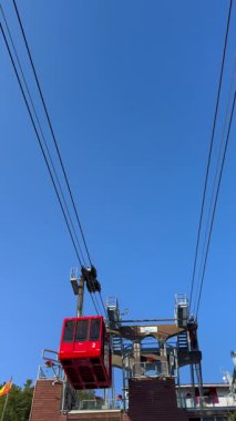 Kırmızı bir teleferiğin benzersiz bir seyahat deneyimi sunduğu, yolcuları el değmemiş doğadan nefes kesici manzaralara taşıdığı anımsatıcı video görüntüleri.. 