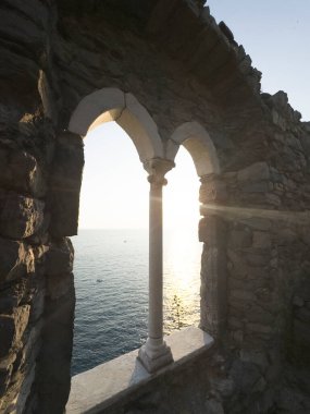 Günbatımında Ligurian Denizi 'ni çevreleyen antik taş bir pencereden Portovenere' deki pitoresk bir yerden görüntüyü izle 