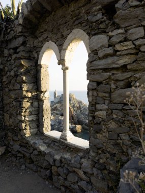 Günbatımında Ligurian Denizi 'ni çevreleyen antik taş bir pencereden Portovenere' deki pitoresk bir yerden görüntüyü izle 
