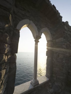 Günbatımında Ligurian Denizi 'ni çevreleyen antik taş bir pencereden Portovenere' deki pitoresk bir yerden görüntüyü izle 