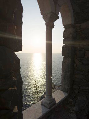 Günbatımında Ligurian Denizi 'ni çevreleyen antik taş bir pencereden Portovenere' deki pitoresk bir yerden görüntüyü izle 