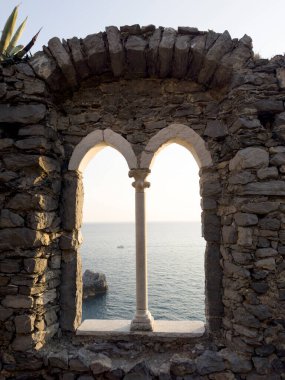 Günbatımında Ligurian Denizi 'ni çevreleyen antik taş bir pencereden Portovenere' deki pitoresk bir yerden görüntüyü izle 
