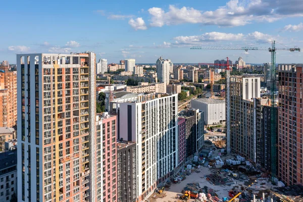 Aerial view of the construction of new residential areas of the city with a view of the horizon, blue sky with white clouds. City photography. Copy space.