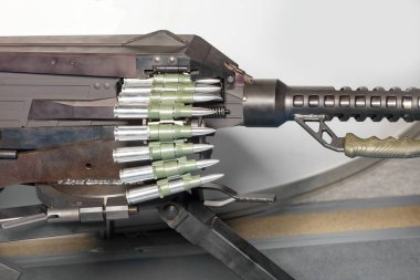 A tape with large-caliber bullets is loaded into a machine gun. Large caliber ammunition belt.